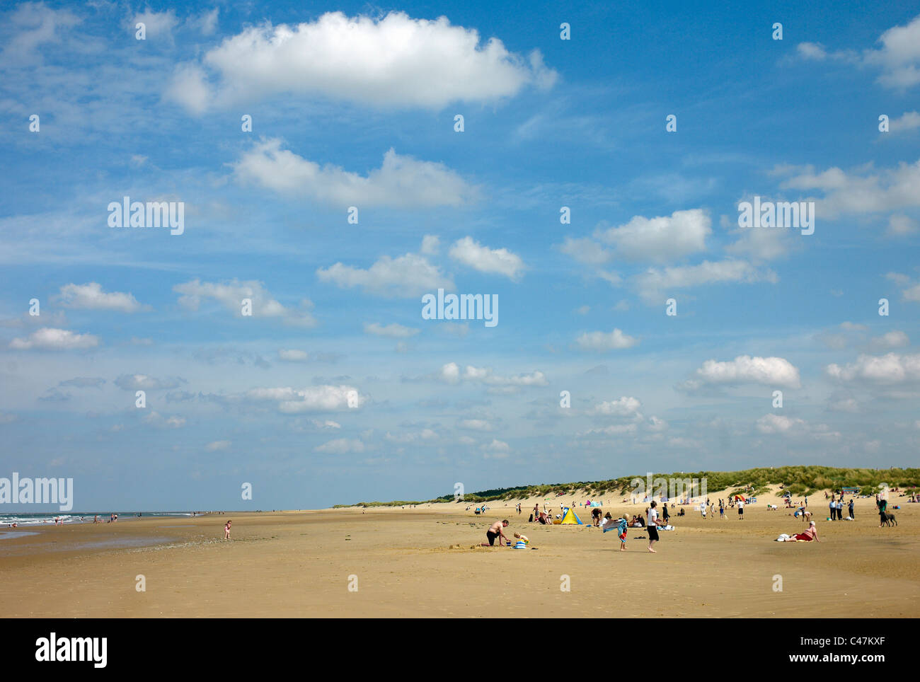 Menschen, die genießen sonnigen Wetter am Holkham Beach, North Norfolk, UK Stockfoto