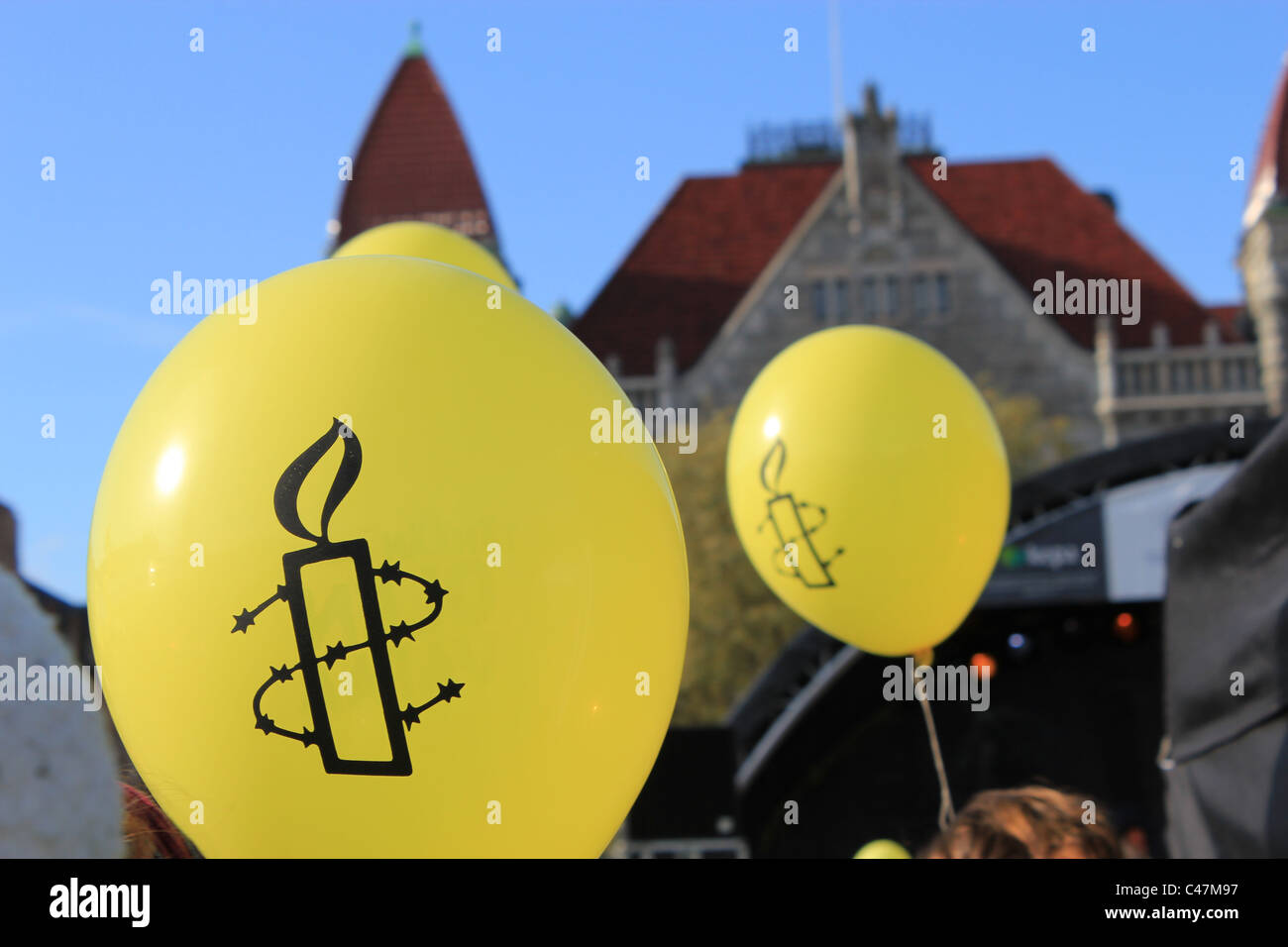 Gelbe Luftballons mit Logos von Amnesty International. Stockfoto