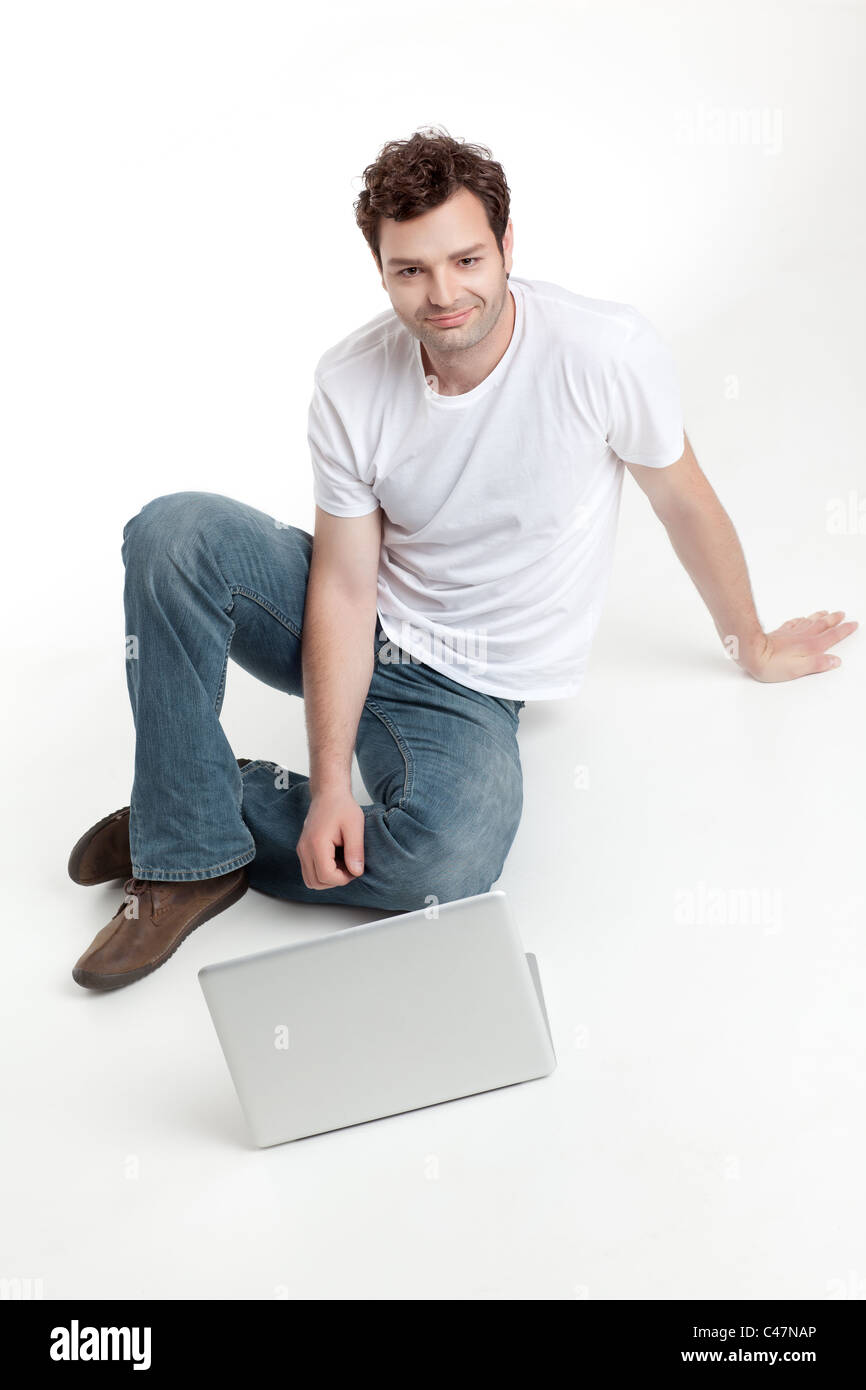 Mann sitzt hinter Blanck Laptop lächelnd Stockfoto