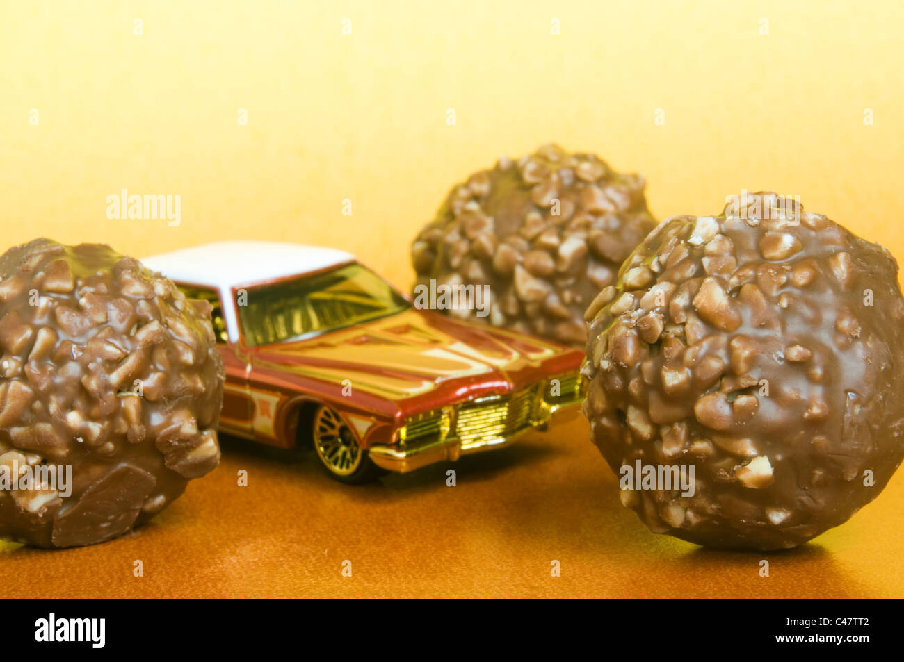Pralinen mit Miniatur-Spielzeug-Auto Stockfoto
