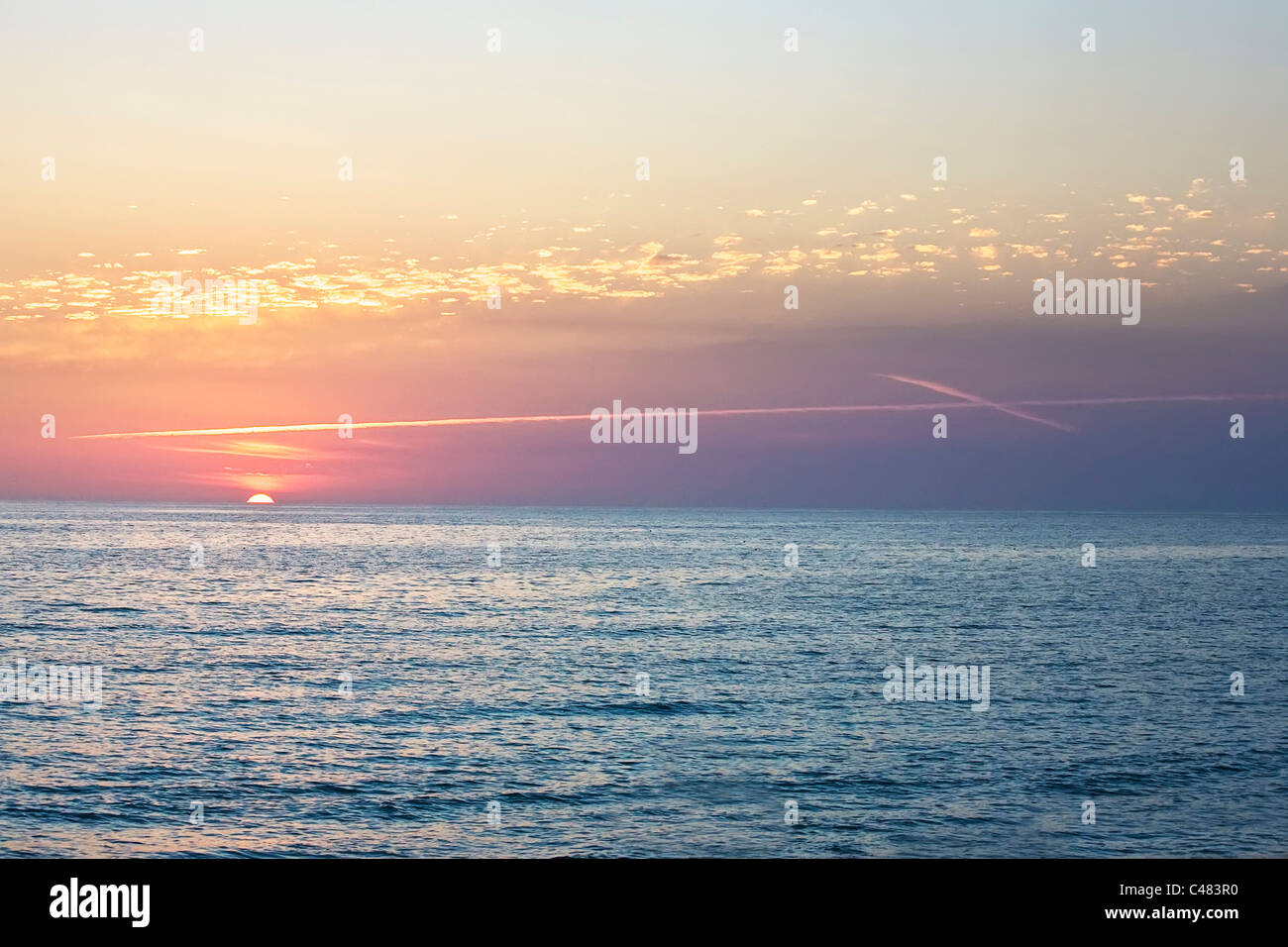 Sonnenuntergang mit Wolken in Form von Kreuz über Golf von Mexiko aus Venice Beach Florida Stockfoto