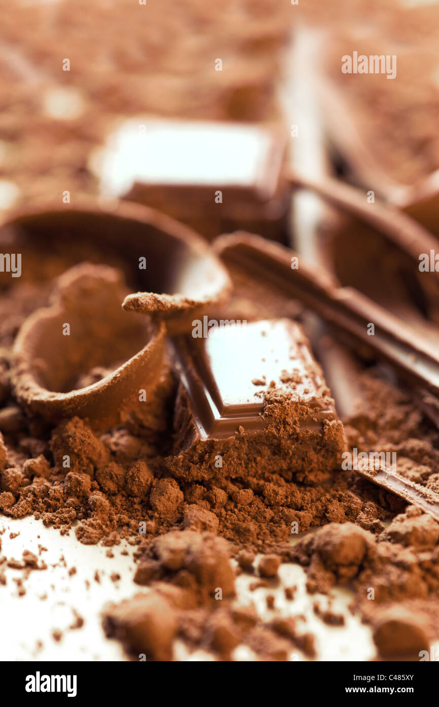 Schokoladen-Hintergrund. Bars und Streifen von Schokolade mit Kakao-Pulver Stockfoto