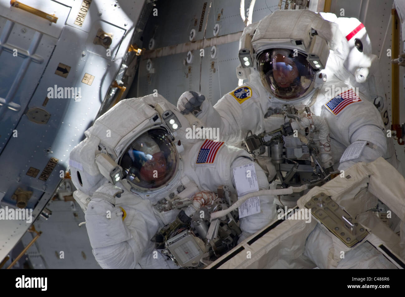 Jenseitige Pas De Deux mit Komponenten von der internationalen Raumstation ISS in der NASA-Astronauten Andrew Feustel (rechts) Stockfoto