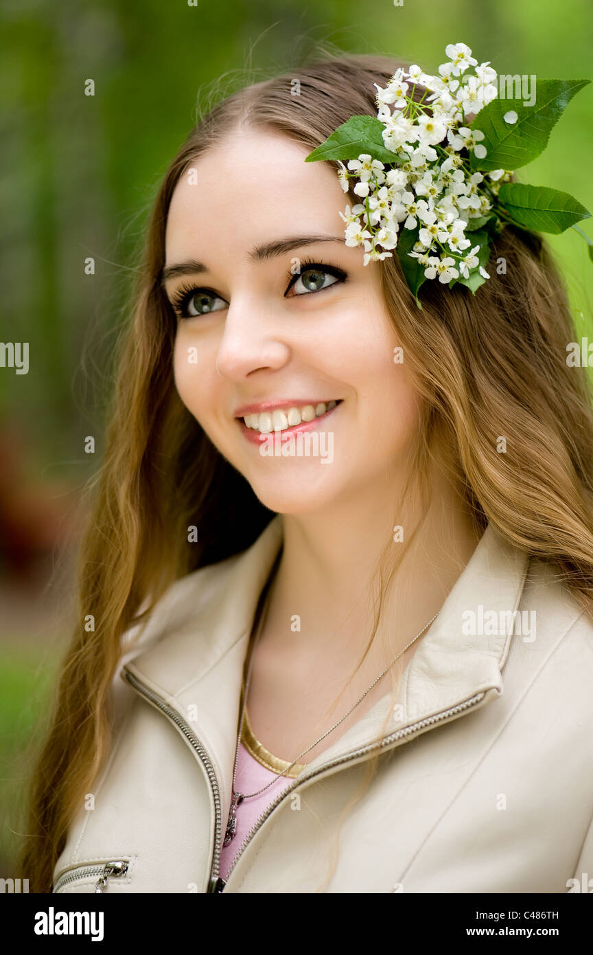 junges Mädchen mit Blumen im Haar in einen Sommerpark Stockfoto