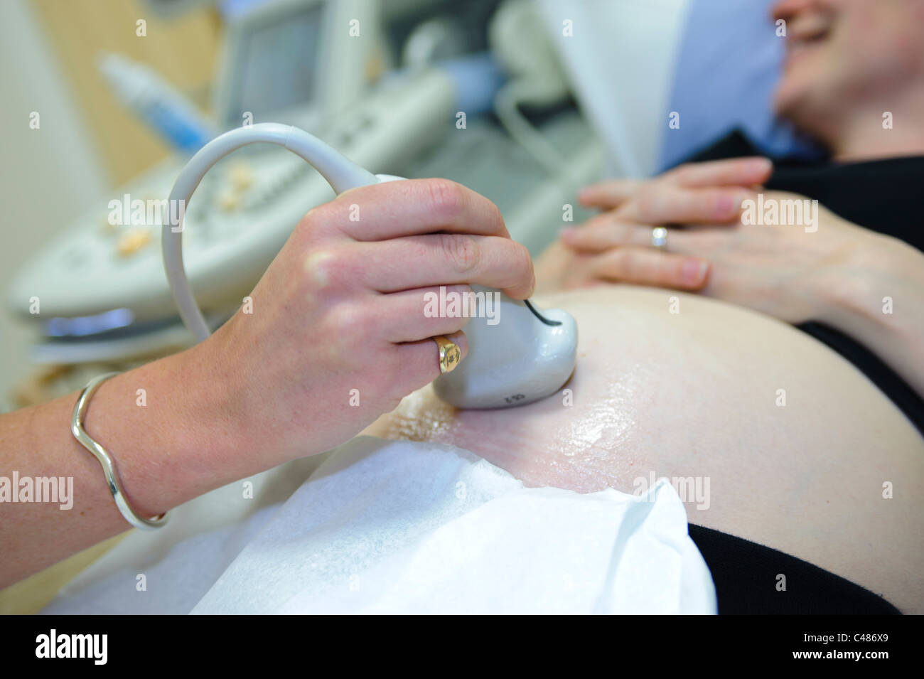 Schwangere Frau auf Beratung Patiententisch Ultraschall scan durch die Ärztin Stockfoto