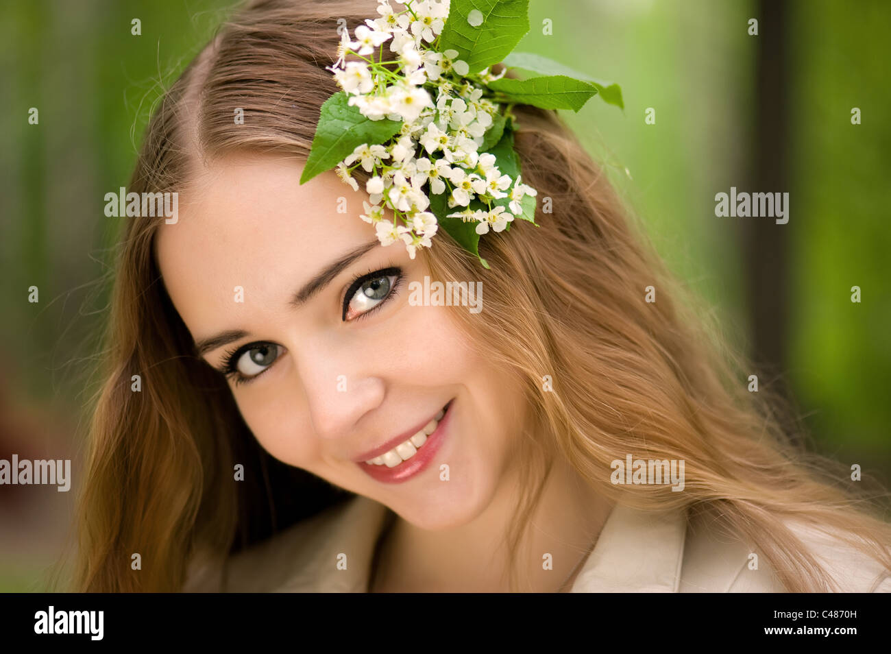 junges Mädchen mit Blumen im Haar in einen Sommerpark Stockfoto