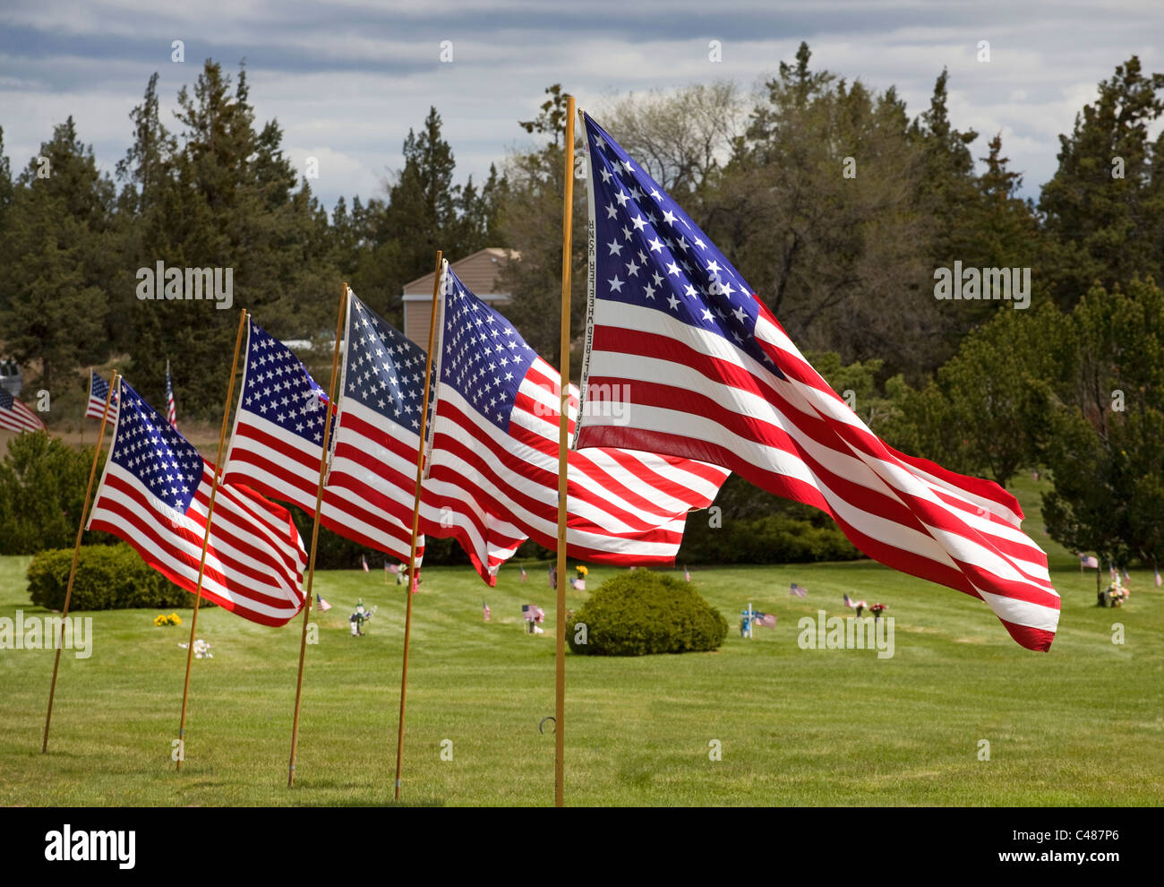 Amerikanische Flaggen und Blumen fliegen über einen Friedhof am Memorial Day Stockfoto