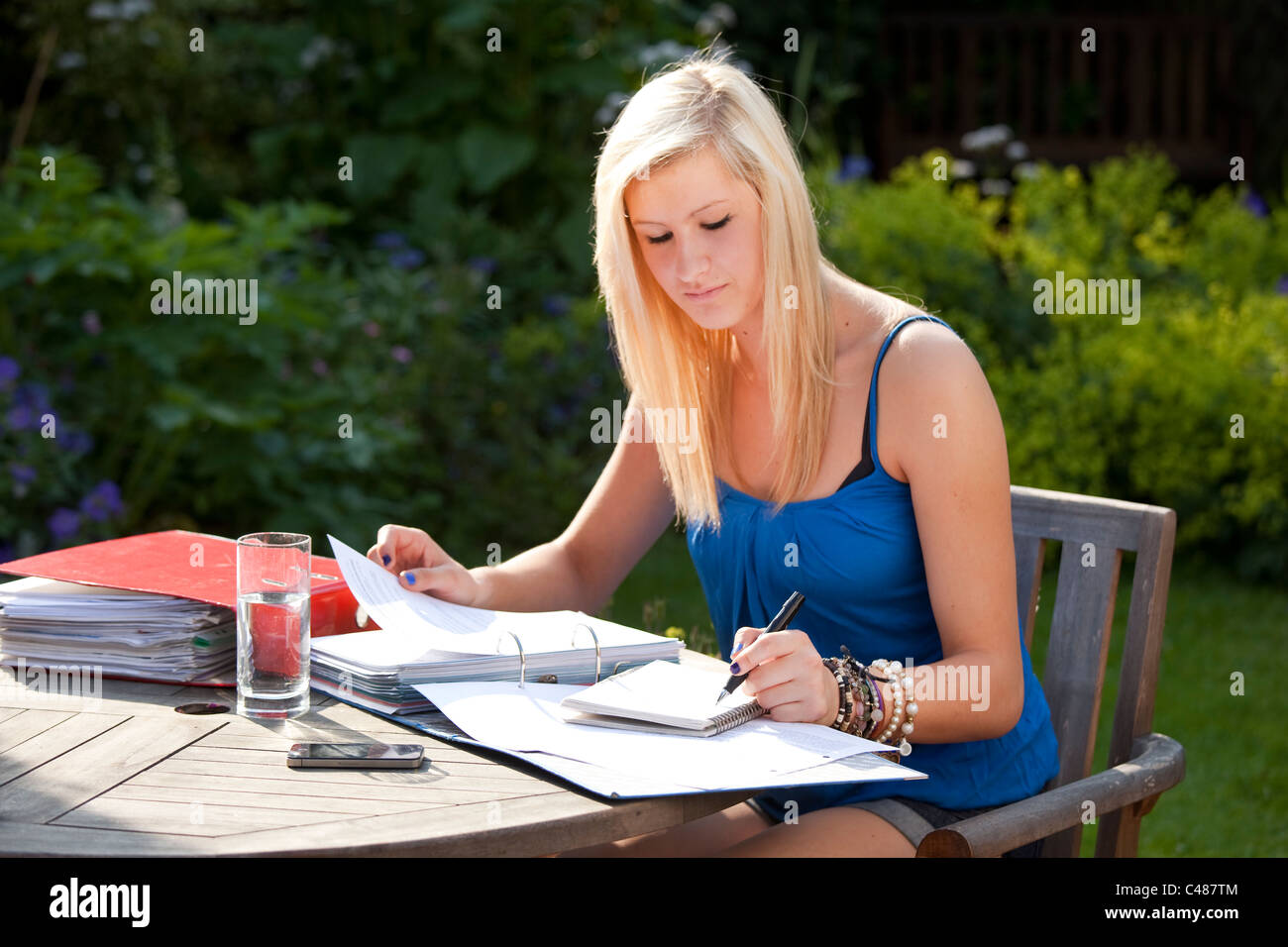 junge Studentin arbeiten und Revision für Prüfungen im Garten Stockfoto