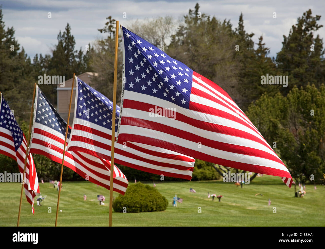 Amerikanische Flaggen und Blumen fliegen über einen Friedhof am Memorial Day Stockfoto