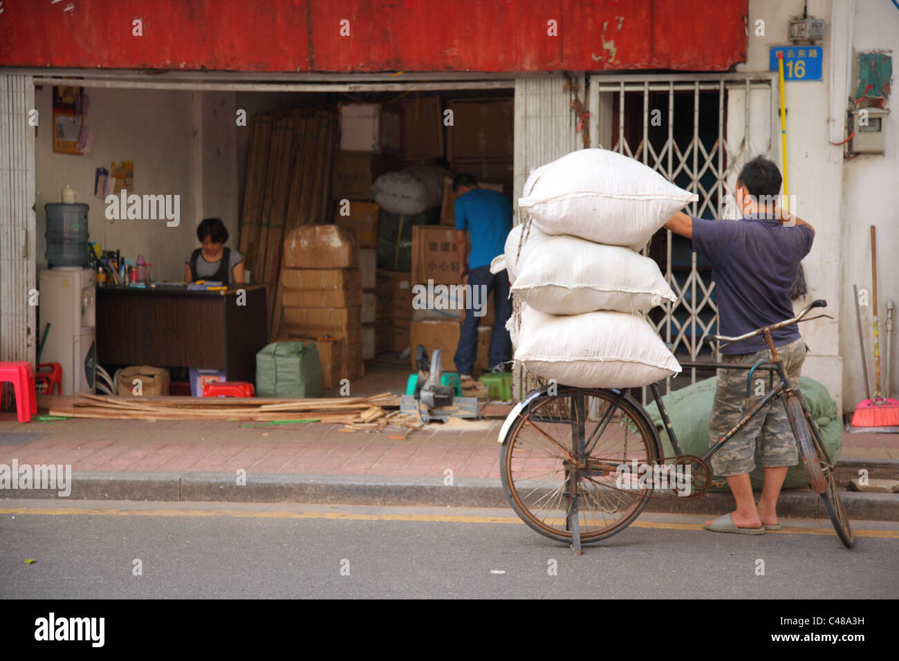 Säcke des Produkts auf dem Fahrrad außerhalb Markt, Guangzhou, China Stockfoto
