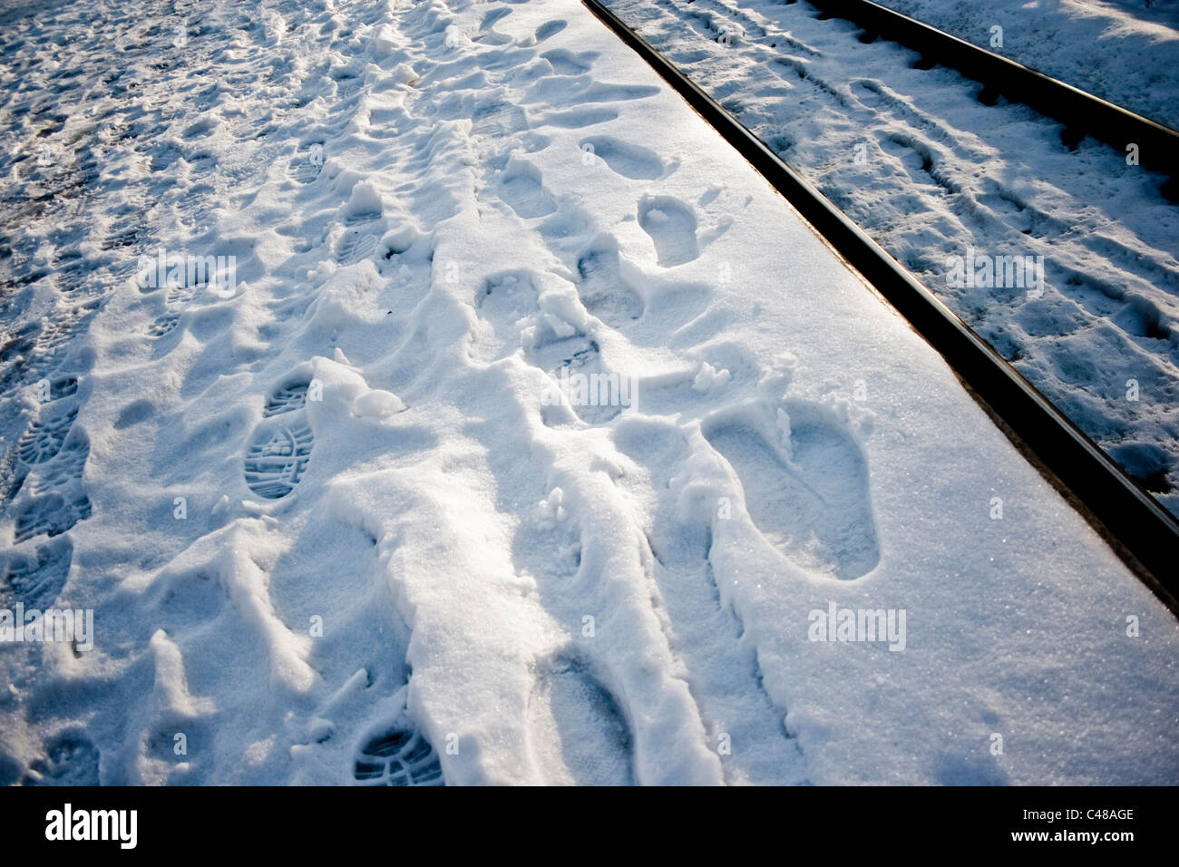 Beweise für eine große Anzahl von Passagieren im Schnee von einem Bahnsteig. Stockfoto