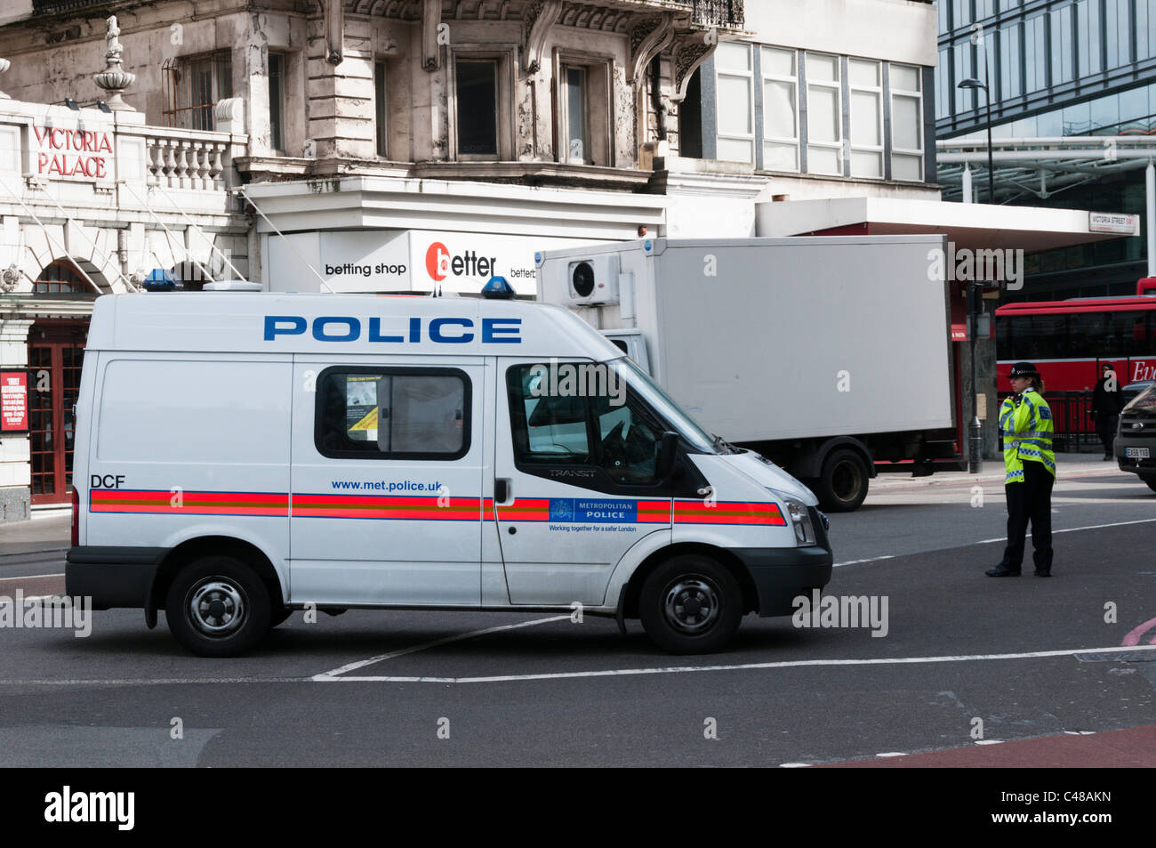 Eine Polizistin steht neben einem Metropolitan Police Transit van Sperrung einer Straße im Zentrum von London. Stockfoto