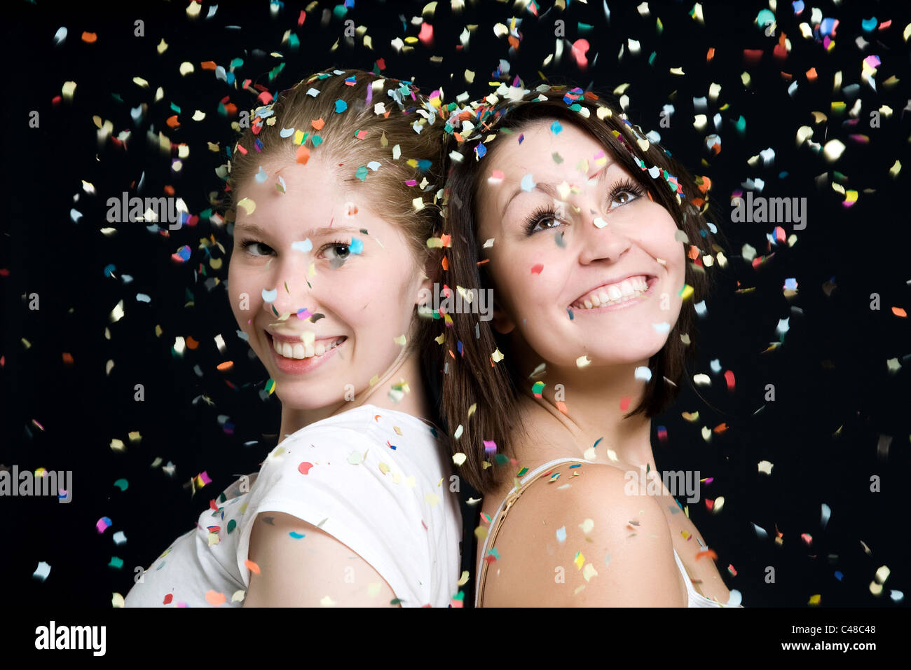 Zwei junge Frauen in einem Regen von Konfetti Stockfoto