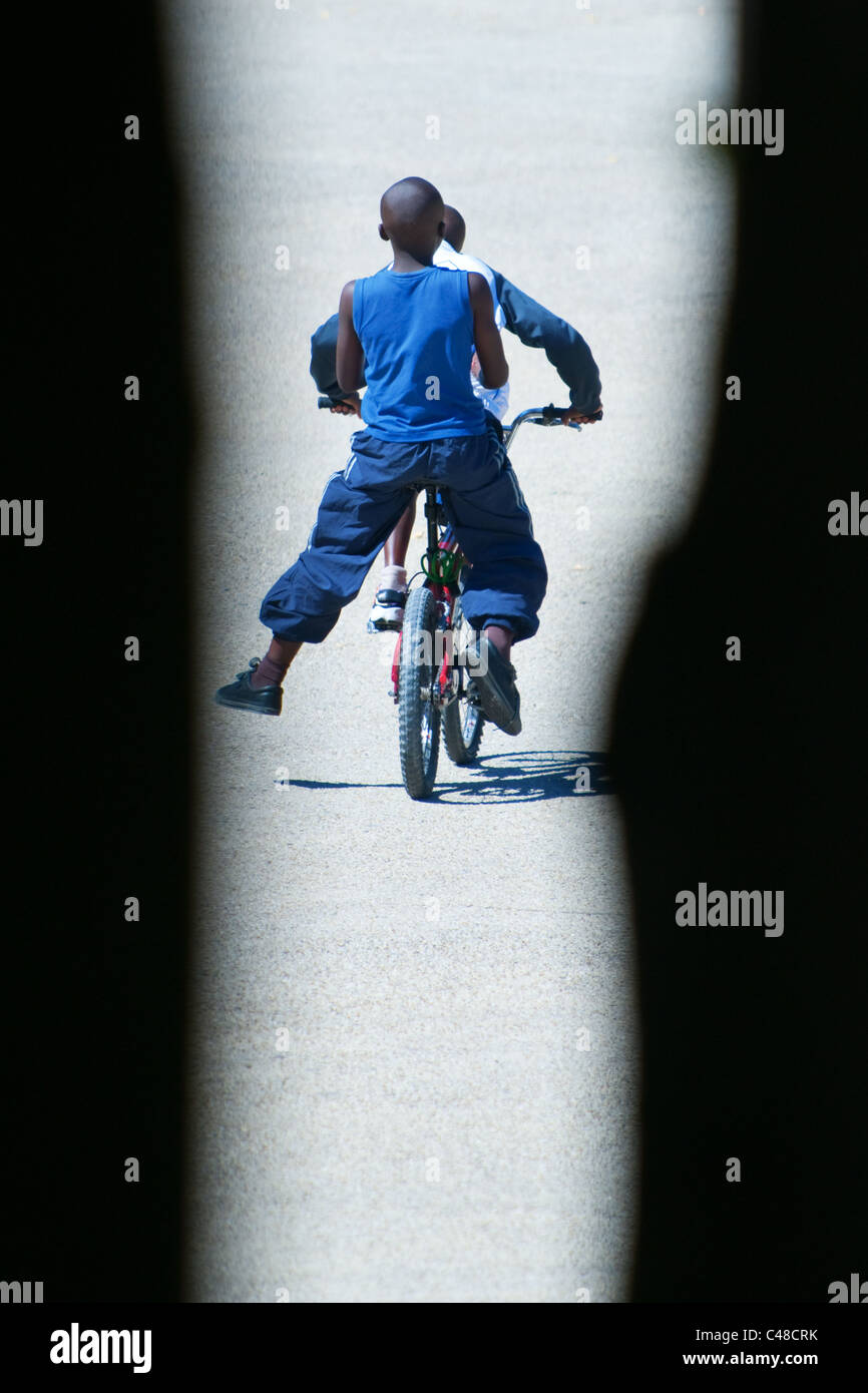 Zwei jungen fahren den gleichen Zyklus Stockfoto