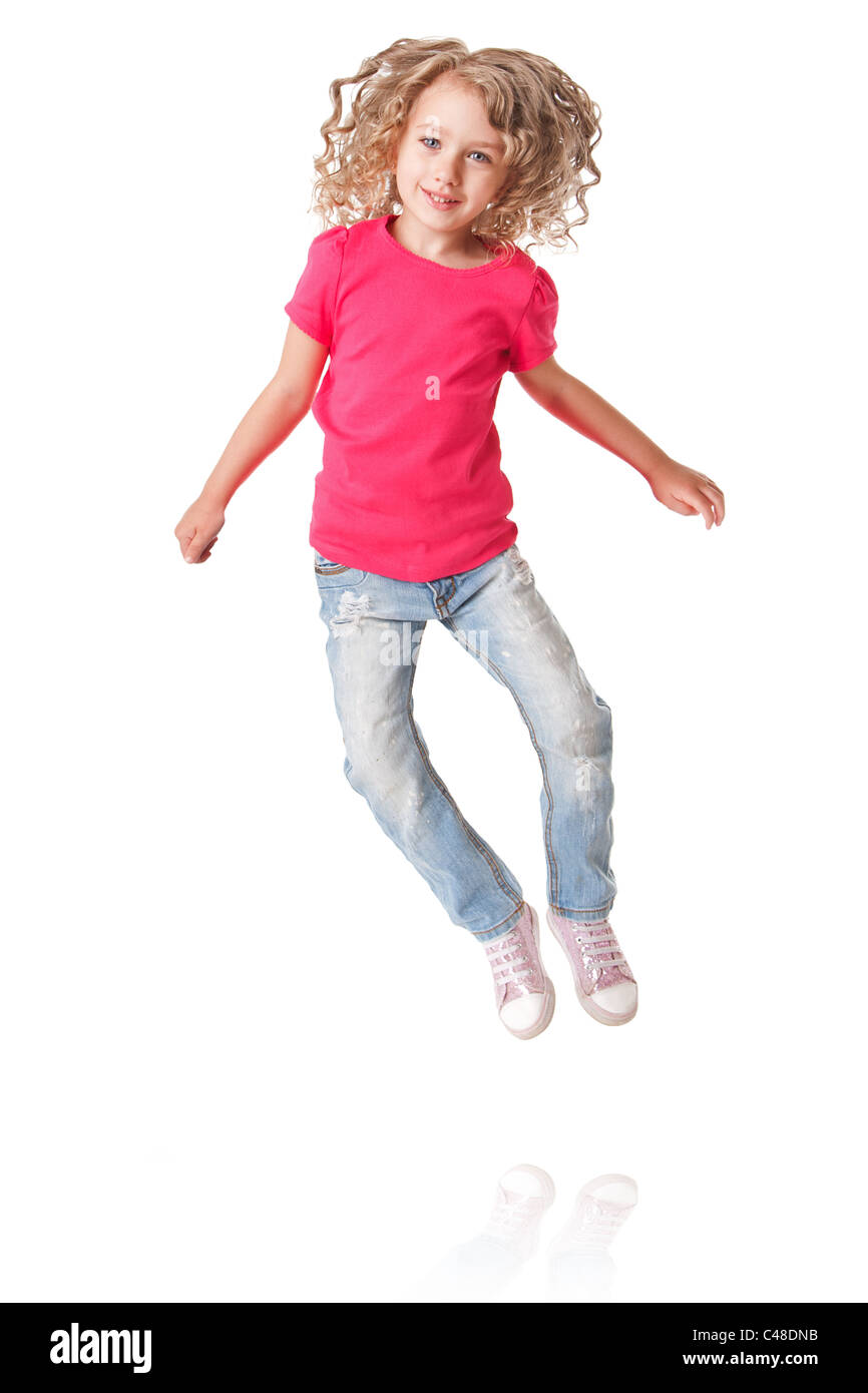 Niedliche glücklich lächelnd isoliert von Freude Mädchen mit Fersen zusammen in rosa Hemd und Jeans, springen. Stockfoto