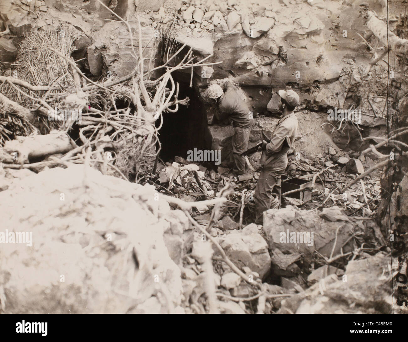 Corporal Leone Oliver wirft Rauchgranate in Höhle. IWO Jima. März 1945 Stockfoto