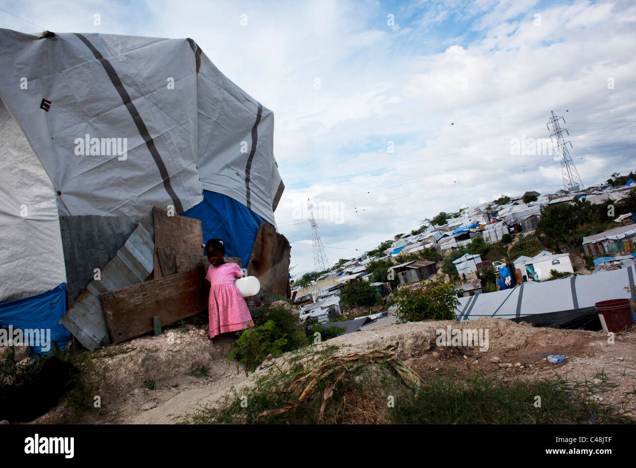 Kleines Mädchen draußen in einem Zelt im Flüchtlingslager. Stockfoto
