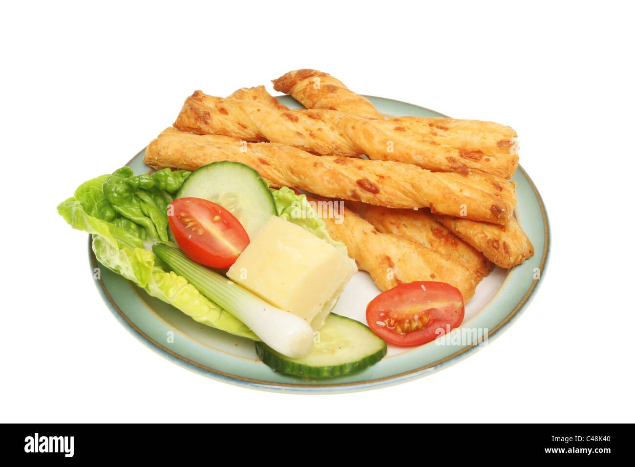 Käse Wendungen und Salat garniert auf einer Platte isoliert gegen weiß Stockfoto