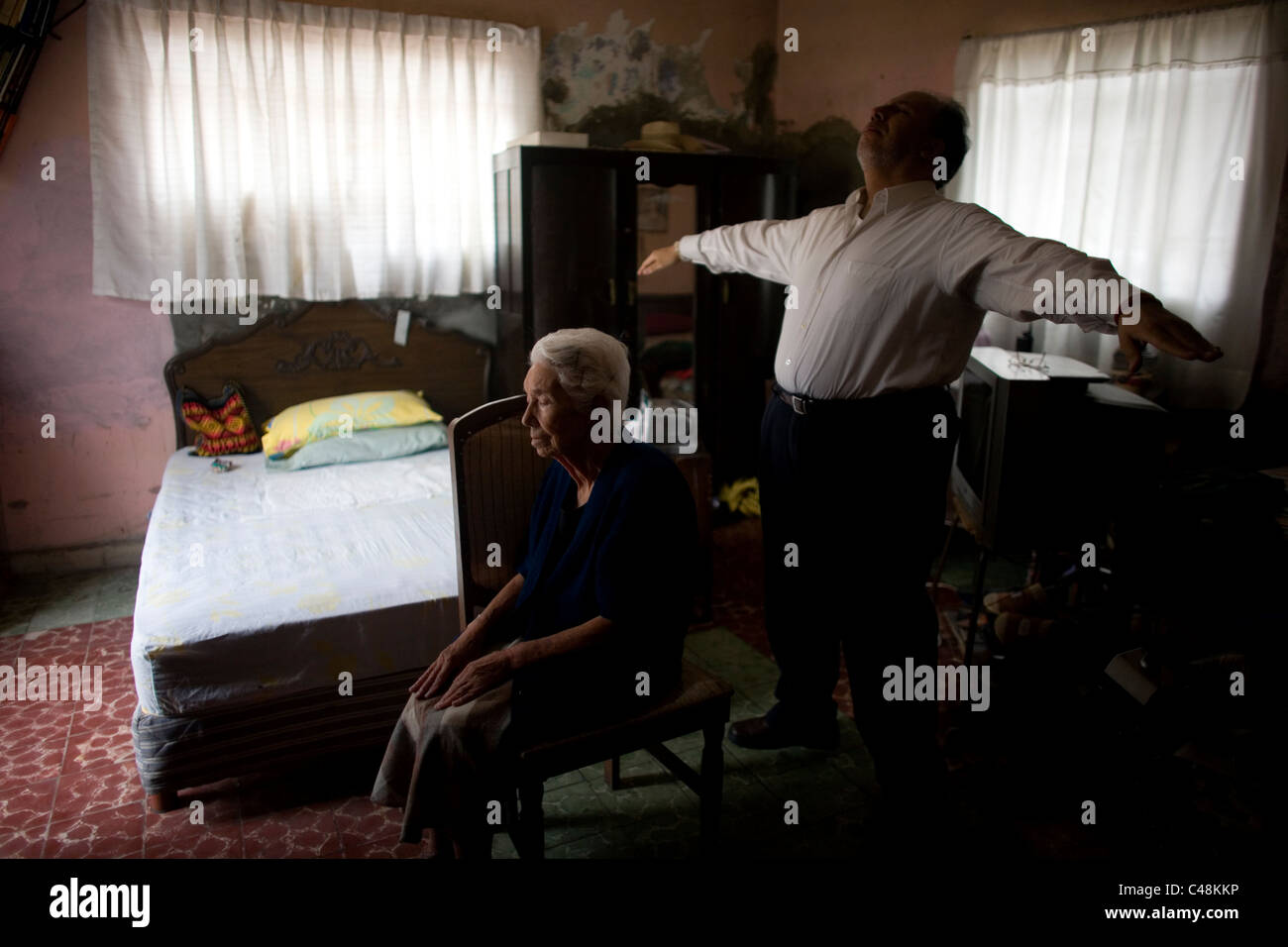 Reiki-Meister Ramon Quiroz bereitet sich auf Reiki geben, ein älterer Patient in ihrem Haus in Mexiko-Stadt Stockfoto