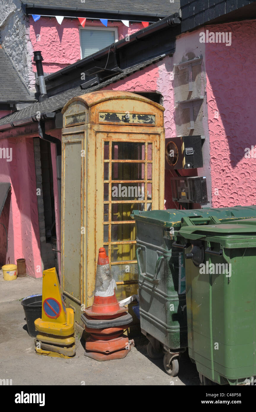 Ein Wetter geschlagenen Telefonzelle neben Mülltonnen hinter einem Pub in Cornwall Stockfoto