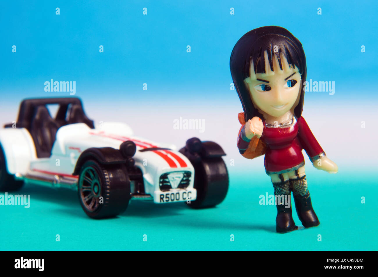 Miniatur-Spielzeug-Auto mit Miniatur-Kunststoff-Puppe Stockfoto