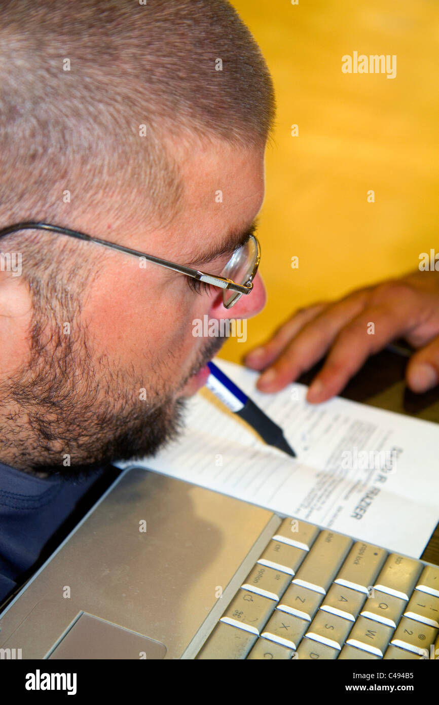 Tetraplegiker argentinischen Mann seinen Namen mit dem Mund in Buenos Aires, Argentinien unterzeichnen. Stockfoto