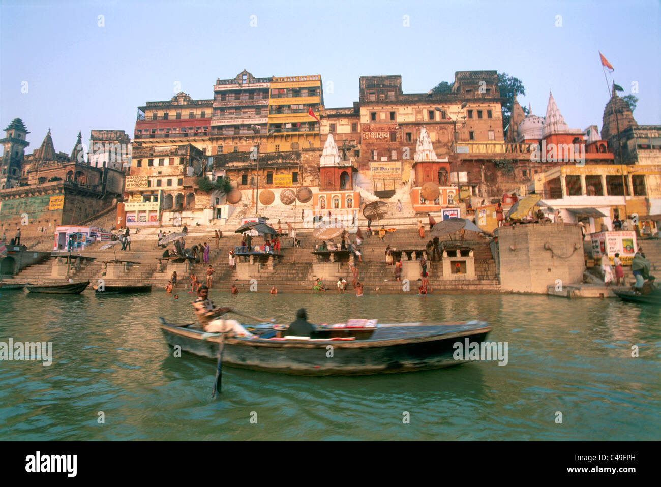 Fotografieren eines Mannes sein Ruderboot auf einem Fluss in Varanasi, Indien Stockfoto