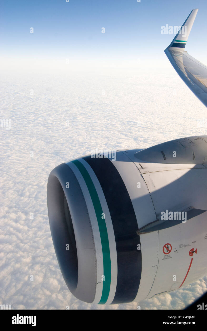 Jet-Engine (737-900) und Flügelspitze über den Wolken Stockfoto
