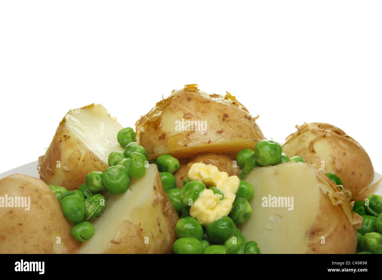 Nahaufnahme von gekochten neuen Kartoffeln und Erbsen mit einem Stückchen Butter schmelzen Stockfoto