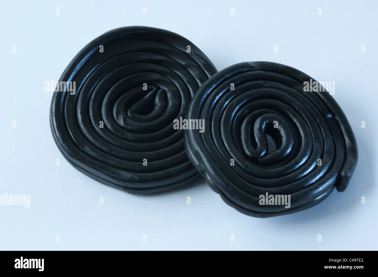 Lakritze (Glycyrrhiza Glabra). Lakritz-Räder, Studio Bild vor einem weißen Hintergrund. Stockfoto