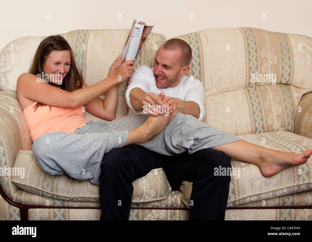 Mann kitzeln Frau Fuß Stockfoto