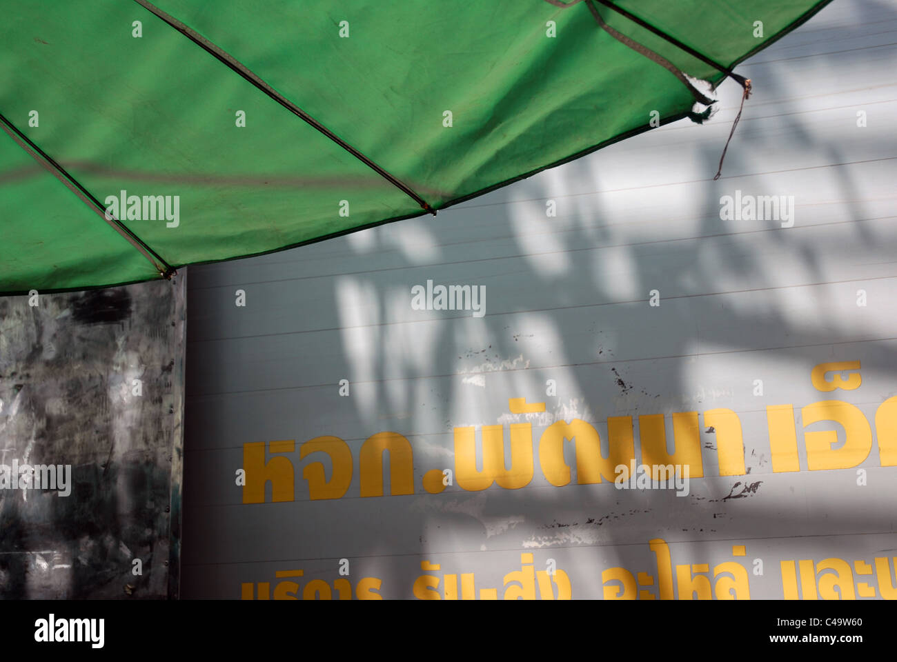 Gelbe Schrift auf Wand, Bangkok, Thailand. Stockfoto