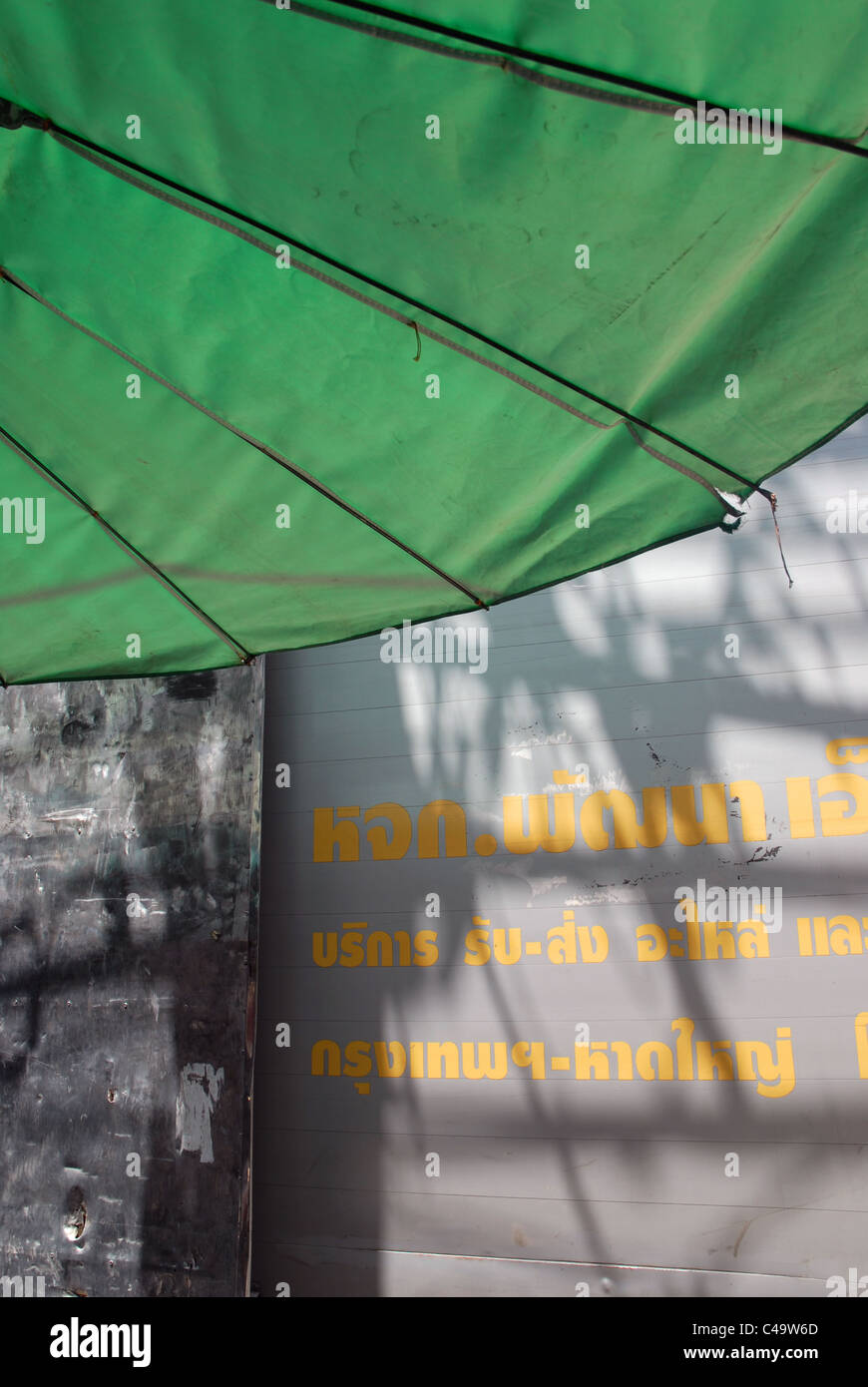 Gelbe Schrift auf Wand, Bangkok, Thailand. Stockfoto