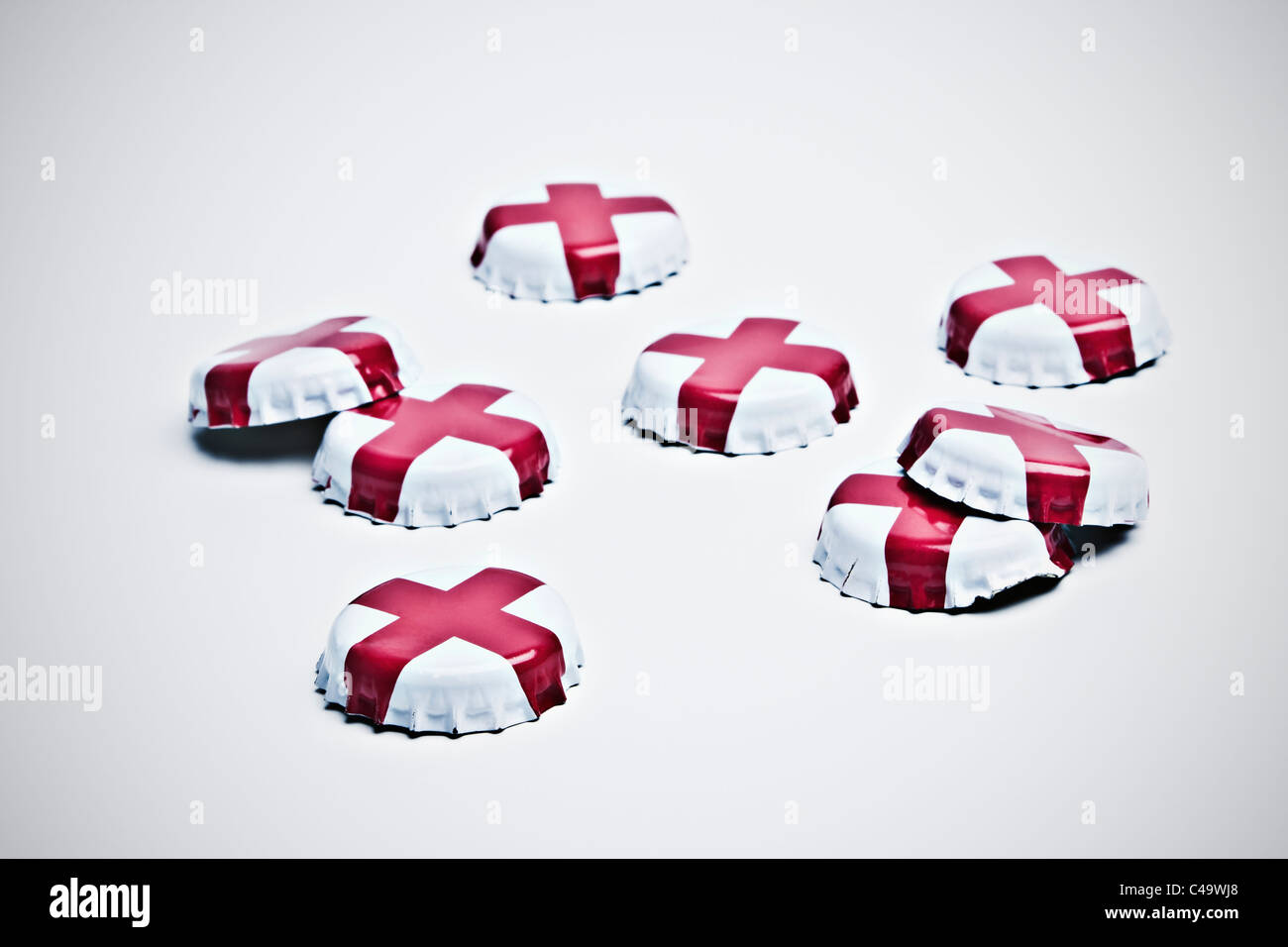 Acht Bier-Kronkorken mit St Georges Cross Emblem auf weißem Hintergrund Stockfoto