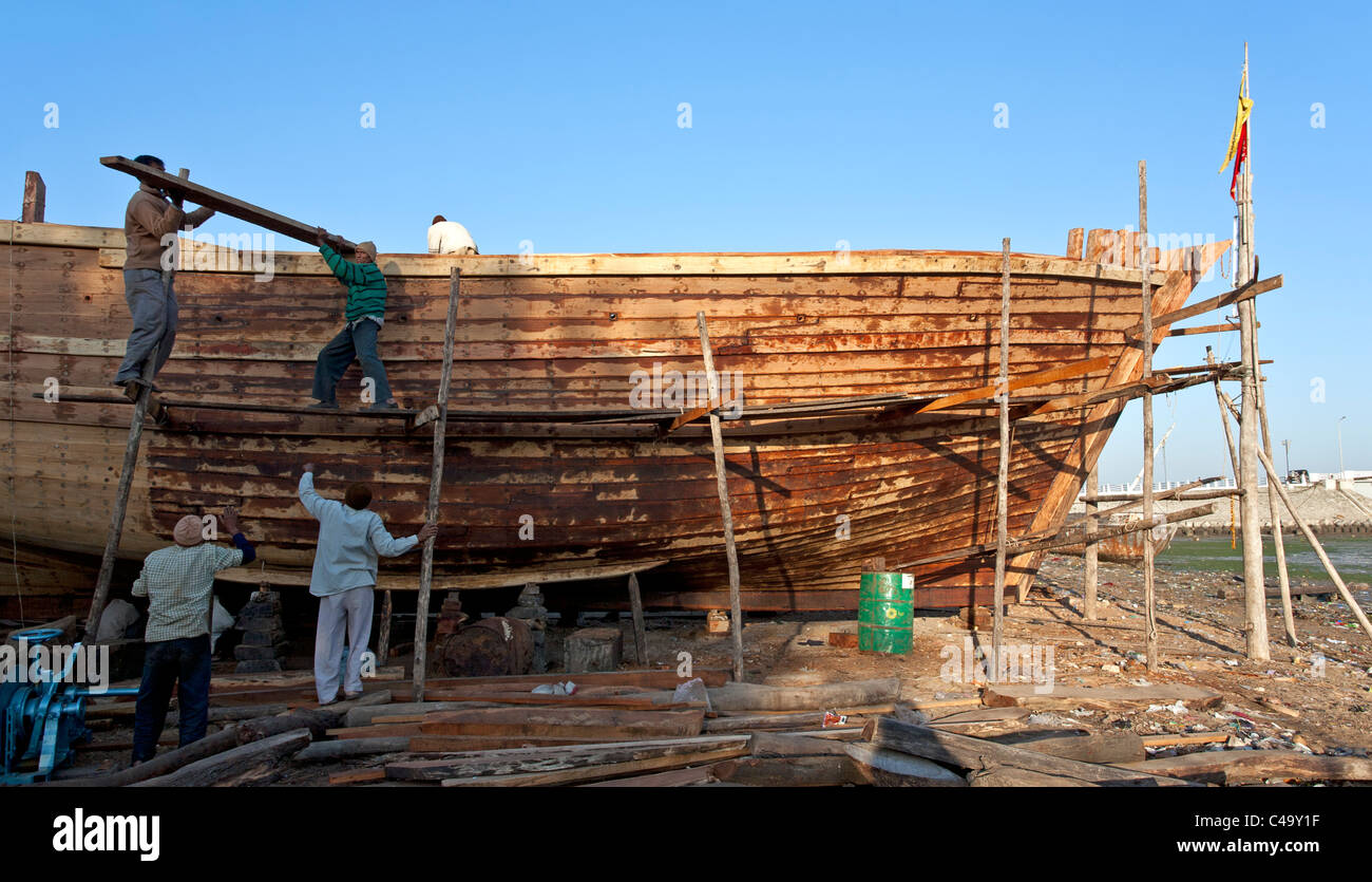Männer, die einem traditionellen Fischerboot Gebäude. Werft. Diu Insel. Gujarat. Indien Stockfoto