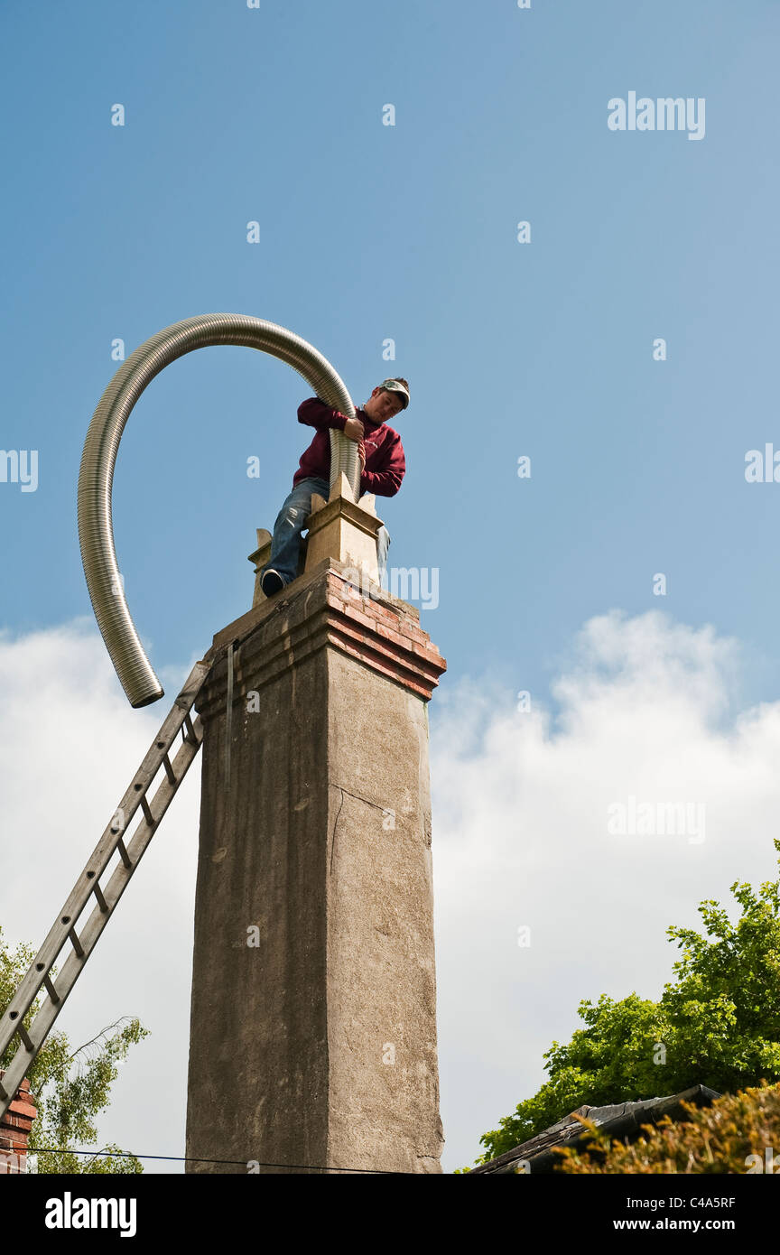 Einen flexiblen Schornsteinliner in einen alten Schornstein einführen, UK Stockfoto