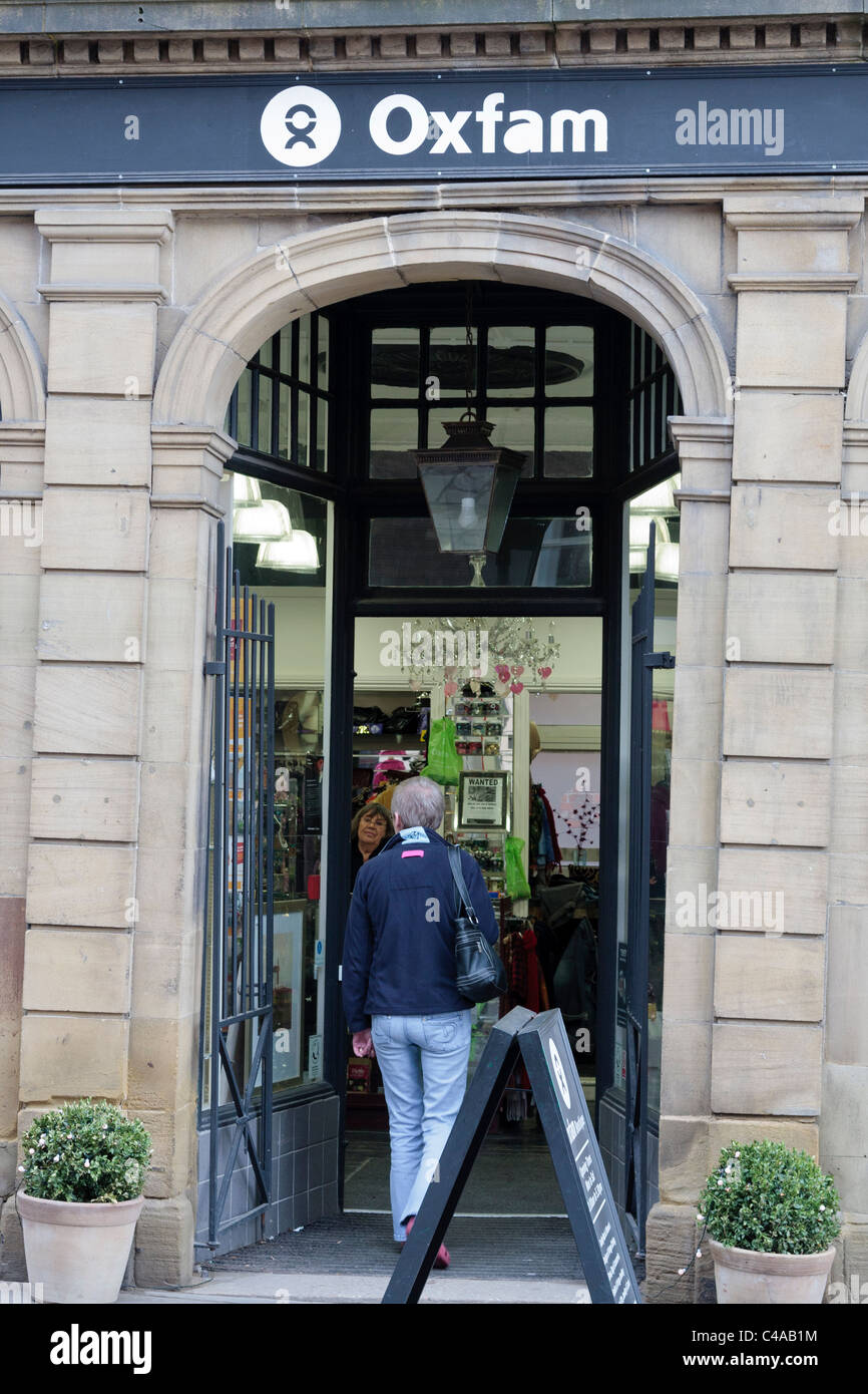 Eingang zu der Oxfam Shop in Durham Frau zu Fuß und Ladenbesitzer Ausschau, Durham, England, UK Stockfoto