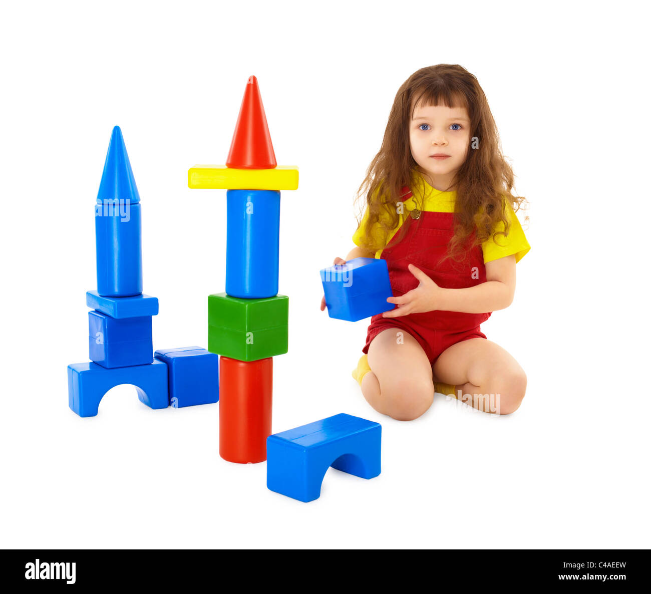 Das Kind baut eine Burg Spielzeug auf dem Boden isoliert auf weißem Hintergrund Stockfoto