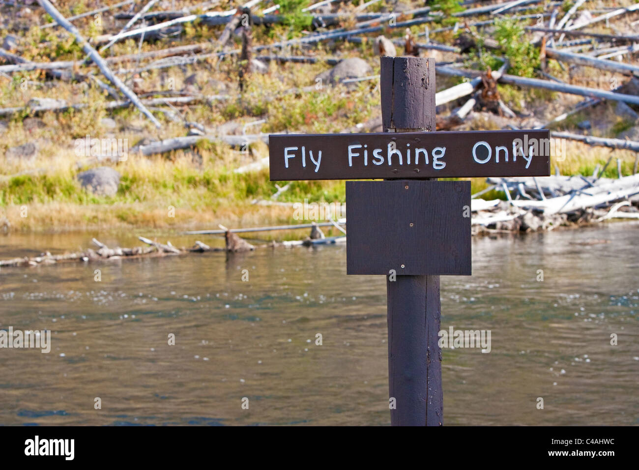 Gebuchte Zeichen entlang eines Flussufers (Firehole River) im Yellowstone National Park zeigt nur "Fliegenfischen" ist erlaubt. Stockfoto