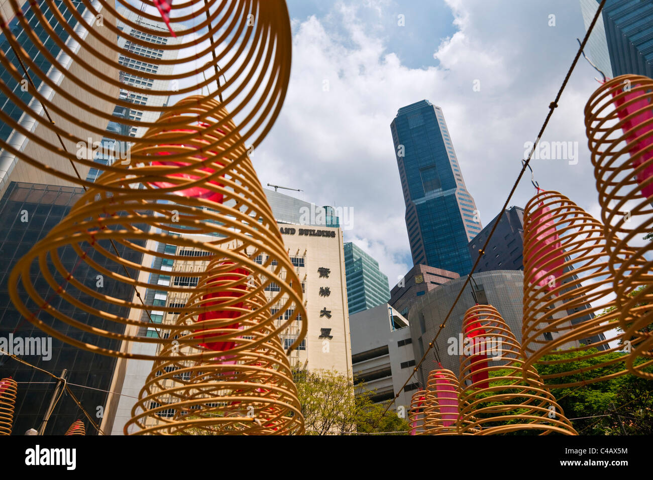 Singapur, Singapur, Raffles Place. Spirale Weihrauch Spulen mit Skyline der Stadt im Hintergrund bei Wak Hai Cheng Bio Tempel. Stockfoto