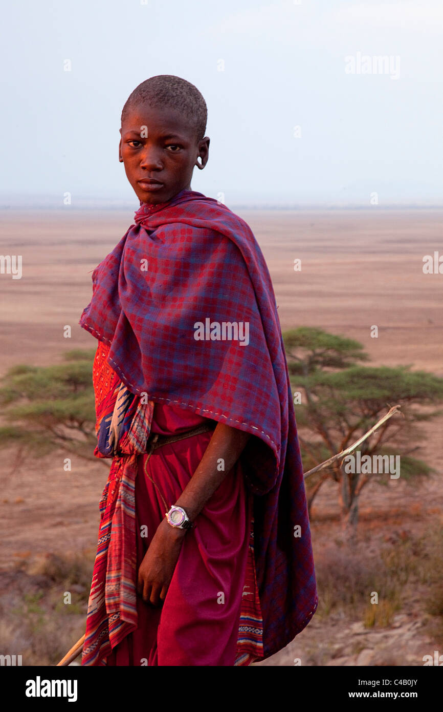 Tansania, Olduvai. Ein Massai-junge sportliche eine schicke Uhr gebadet im Abendlicht. Stockfoto