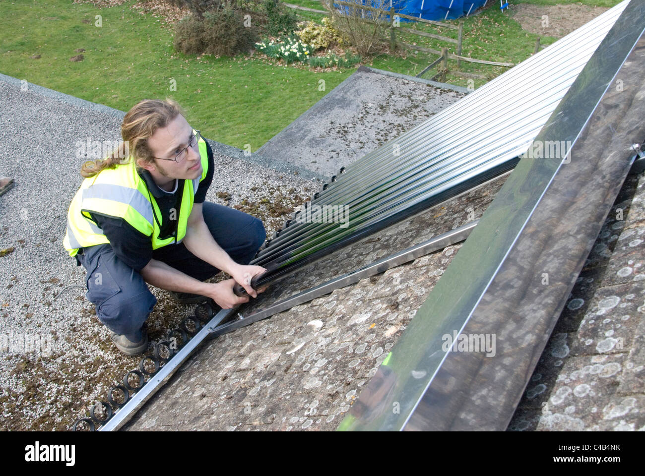 Ingenieure, die Installation solar thermische evakuierten Röhre Array auf dem Dach eines inländischen Hauses Erneuerbare Wärme und Warmwasser Stockfoto