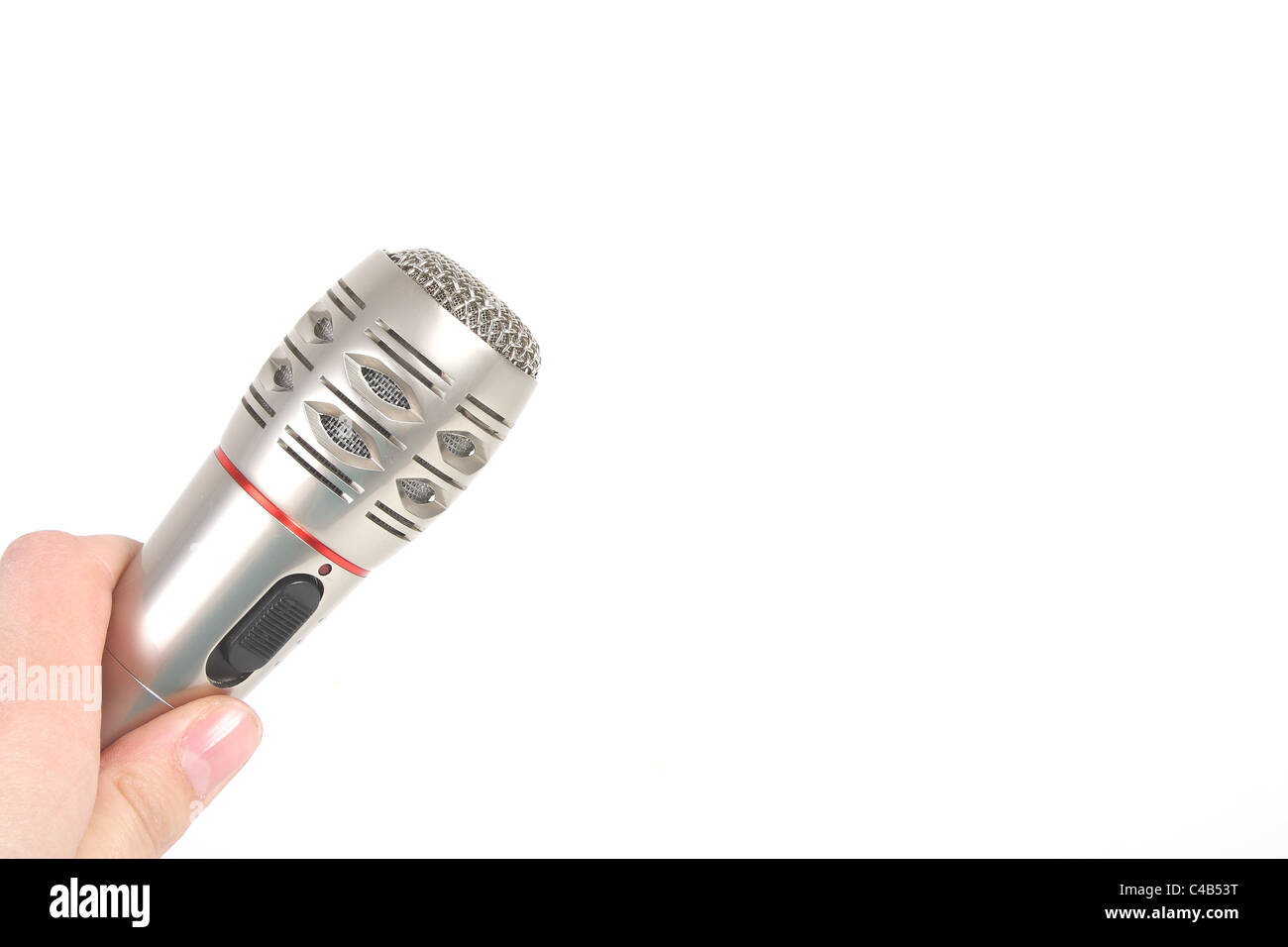 Eine Kaukasische Frau hält eine silberne Mikrofon auf einen Ausschnitt der weißen Studio-Hintergrund, bereit zu singen oder Karaoke durchführen. Stockfoto