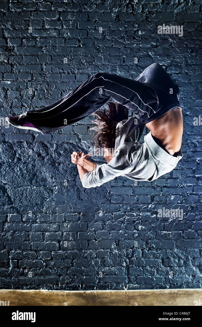 Junge Frau Tänzer springen. Auf Wand Hintergrund. Stockfoto