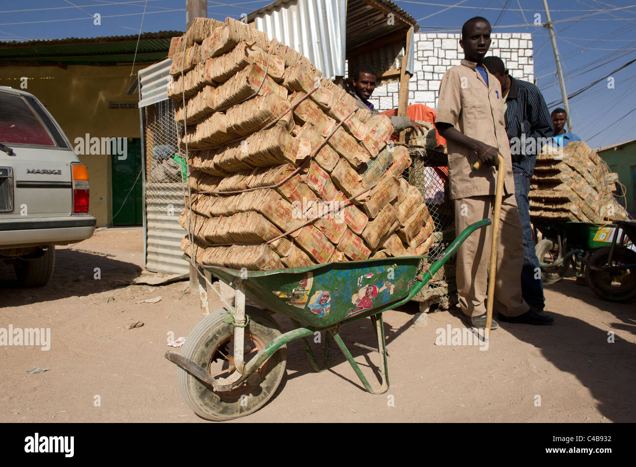 geldwechsler-tragen-lasten-von-geringwertigen-noten-in-schubkarren-auf