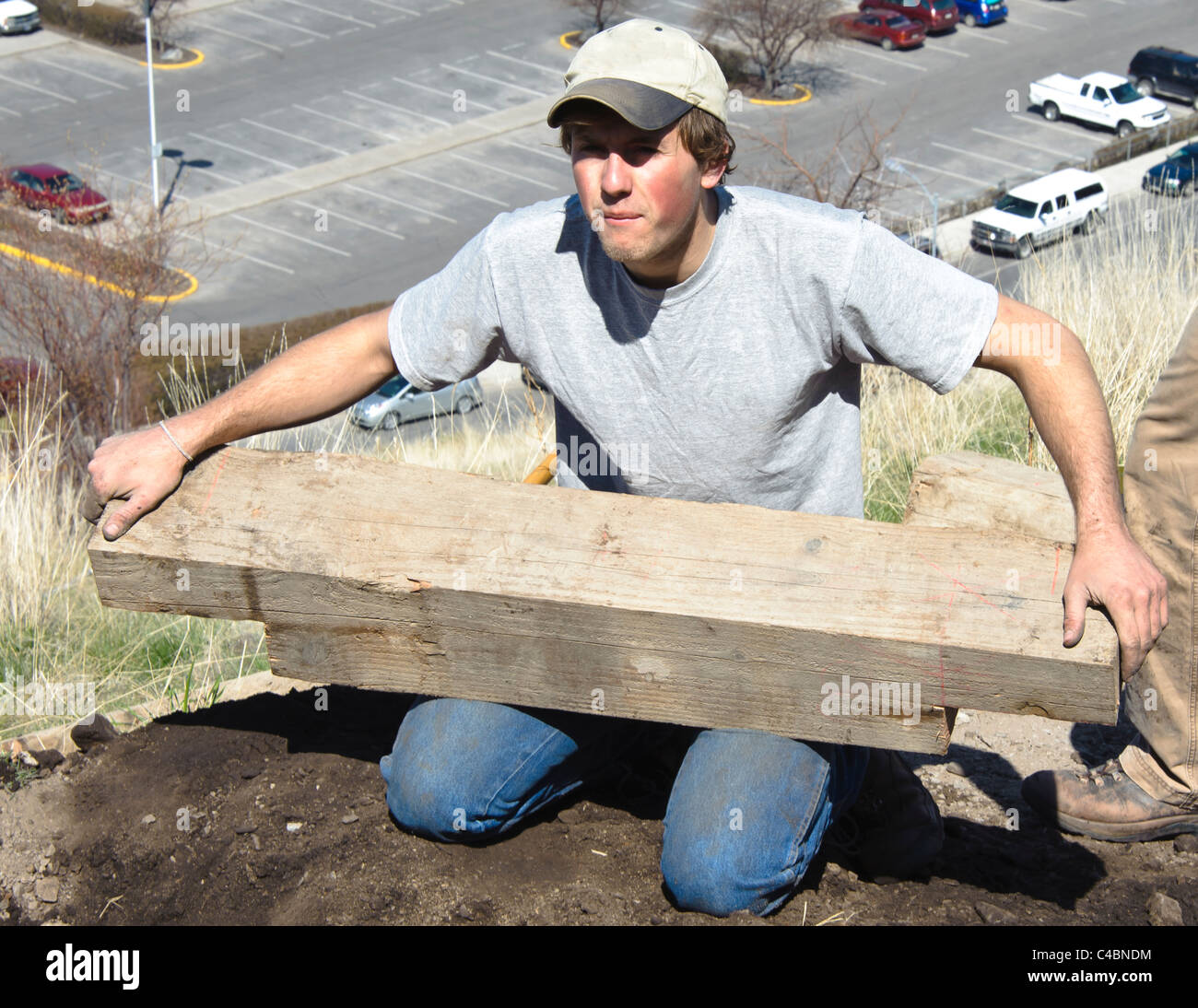 Eine männliche Freiwillige setzt den ersten Schritt auf die neue Basis, die sie bei der ersten kehre auf dem M-Trail bauen. Stockfoto