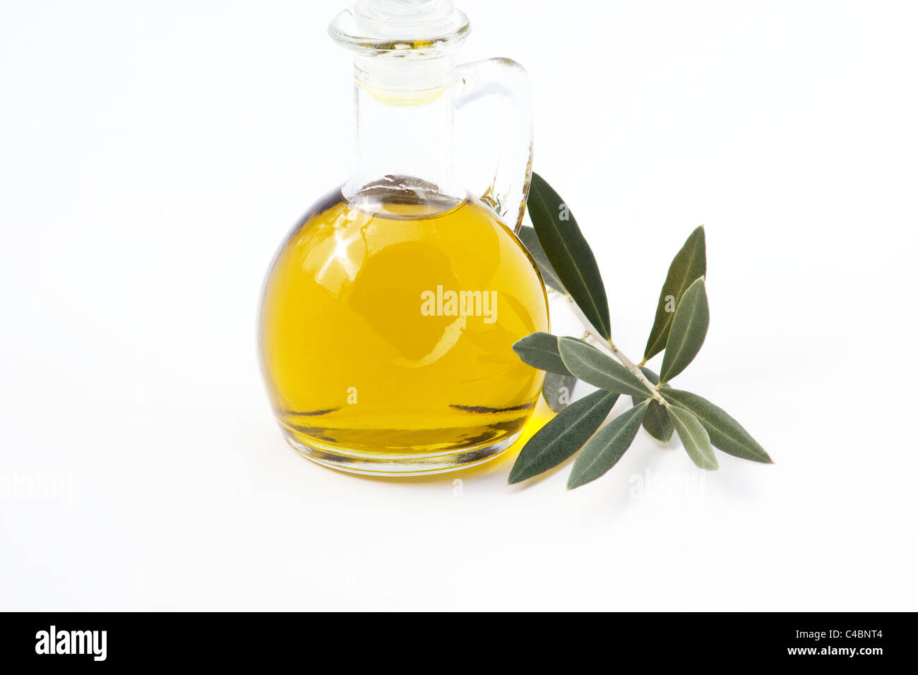Olivenöl und Blätter auf weißem Hintergrund Stockfoto