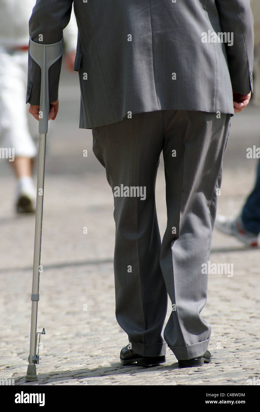 Alter Mann gehen mit Krücken Stockfoto