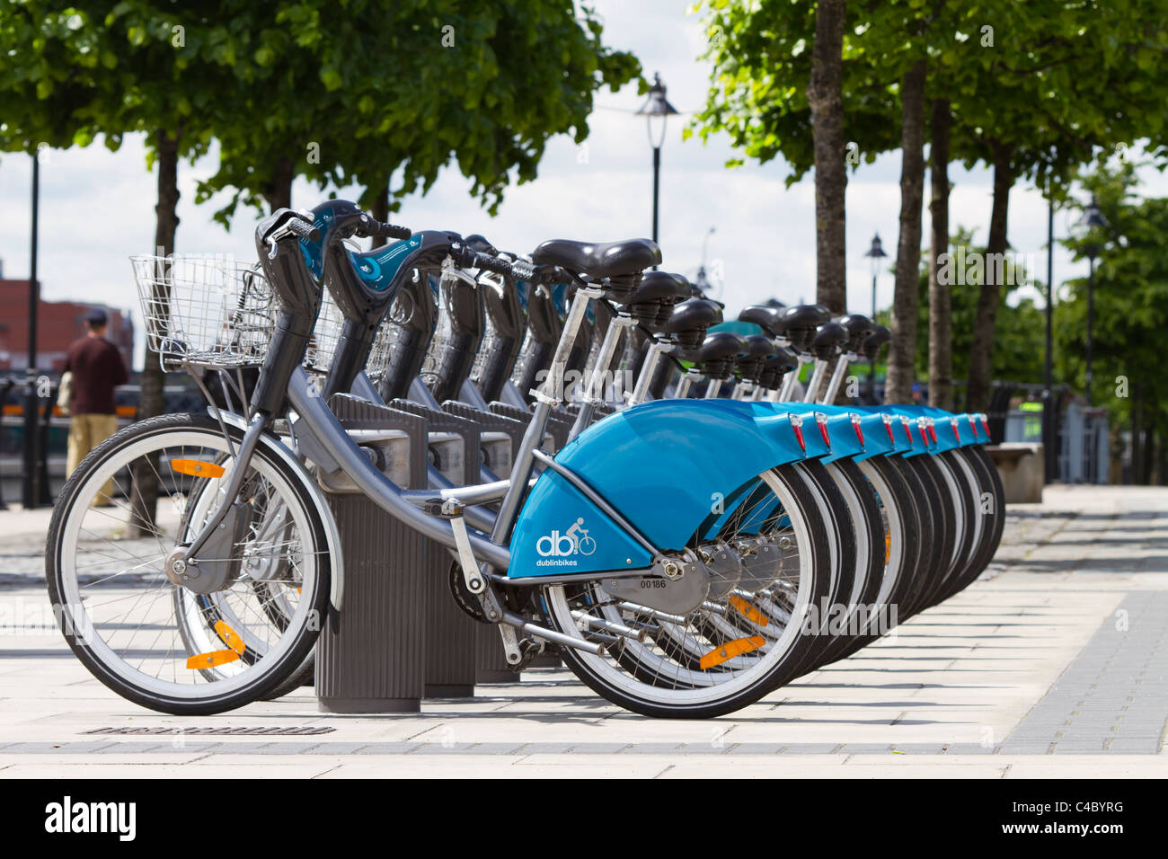 Eine Reihe von Dublin Fahrräder zu vermieten auf dem Georges Quay, Dublin. Ein Passant von kann im Hintergrund zu sehen. Stockfoto