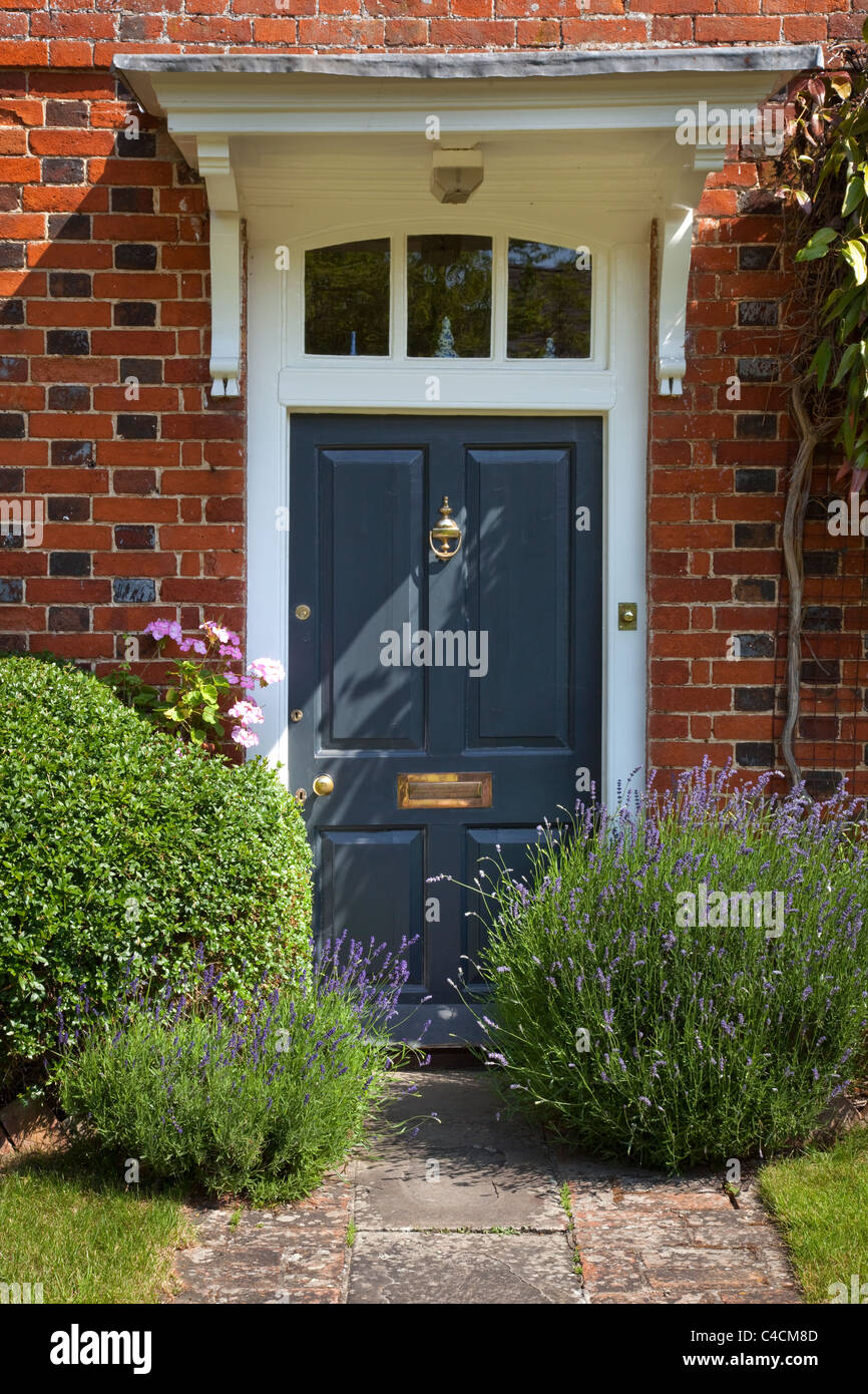 Georgische Tür Eingang zum Haus mit Holz getäfelte Tür Blei Dach Veranda und Stein Weg, gesäumt von Box und Lavendel Stockfoto